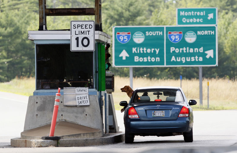 A motorist and her dog wait for change at a toll booth, Thursday, July 19, 2012, in Biddeford. The Maine Turnpike Authority may scale back its proposed toll increase. (AP Photo/Robert F. Bukaty)