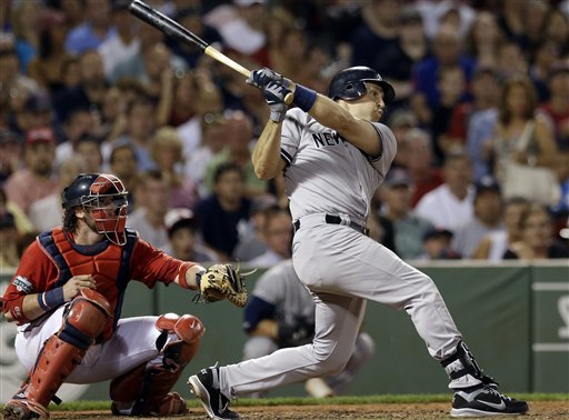 New York Yankees' Mark Teixeira follows through on a two-run triple as Boston Red Sox catcher Jarrod Saltalamacchia watches in the seventh inning of a baseball game at Fenway Park in Boston Friday, July 6, 2012. (AP Photo/Elise Amendola)