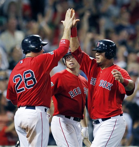 HIGH FIVE: Boston’s Adrian Gonzalez (28) Daniel Nava, center, and Mauro Gomez celebrate after Gonzalez and Gomez scored on a three-run double by Pedro Ciriaco that also drove in Cody Ross in the sixth inning of the second game of a doubleheader against the New York Yankees on Saturday in Boston.