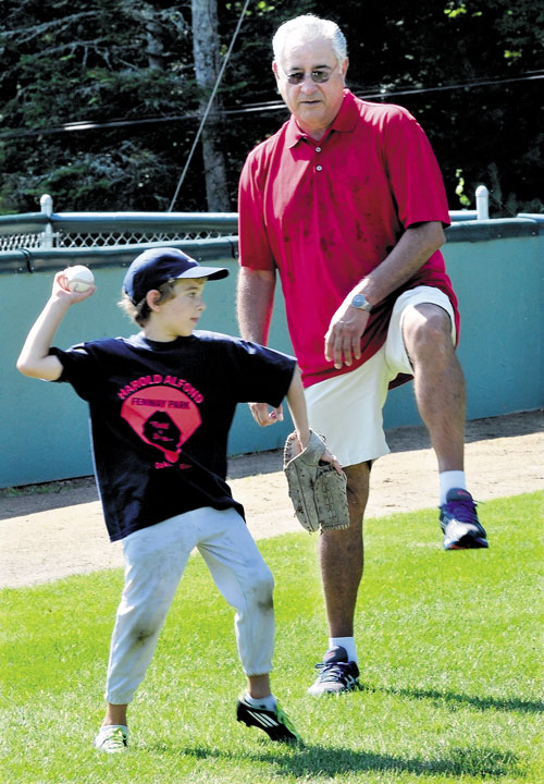 DO IT LIKE THIS: Former Major League baseball player Mike Torrez teaches Max Olmstead to step up when throwing during a baseball camp Monday at Little Fenway Park in Oakland.