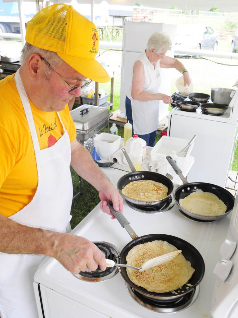 Norman Tondreau, left, and Gloria Morin cook crepes during the Festival de la Bastille on Saturday afternoon in Augusta. In addition to the thin French pancakes there were also boudin, meat and salmon pies, burgers and hot dogs. Today there will be a chicken barbecue from 11 a.m. to 1 p.m.