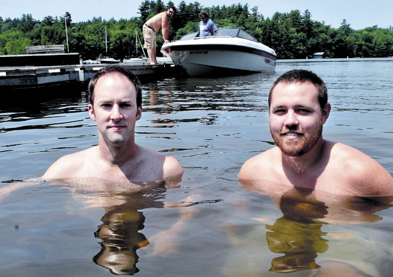 Filmmakers Ryan Brod, left, and Daniel Sites are chest-deep in Great Pond in Belgrade on Sunday. They spent a lot of time there working on the ice fishing documentary "Hardwater," which will premiere at the Maine International Film Festival.