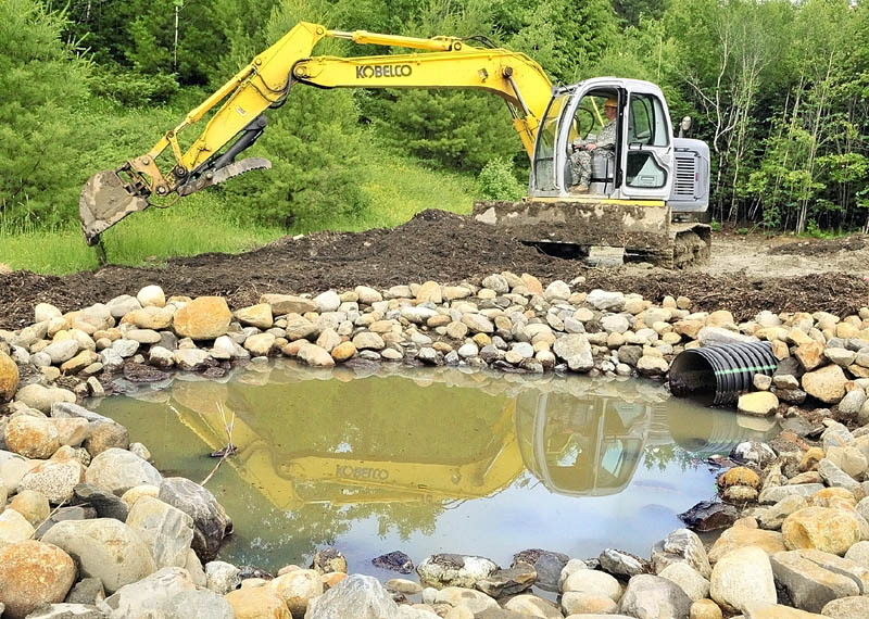 Staff Sgt. Kenneth Merrifield runs an excavator as part of the Maine Army National Guard's summer training project at the Augusta Trails complex on Tuesday in Augusta. The 2nd Platoon of the 262 Engineer Company built as a section of the road in the complex that is located between the Augusta State Airport and Bond Brook Road.