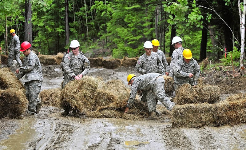 Maine Army National Guard soldiers stack haybales into a check dam to prevent erosion on a road they built during a summer training project at the Augusta Trails complex last week in Augusta. The 2nd Platoon of the 262 Engineer Company built a section of the road in the complex that is located between the Augusta State Airport and Bond Brook Road.