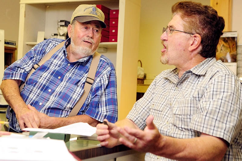 Thomas Donlon, left, and William Guerrette chat about the George Washington funeral medallion that Donlon recently bought on eBay on Thursday at China Lake Coins & Currency, at 285 State St., in Augusta.
