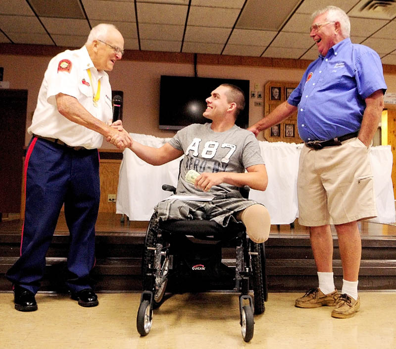 Jeremy Gilley, center, shakes hands with Marine Corps League Detachment No. 599 commandant Don Brawn, left, as Jerry Bechard, 1st Vice President of Le Club Calumet looks on at a fundraiser held on Wednesday night at Le Club Calumet in Augusta. Gilley received donations from the Marine Corps League and the Club.