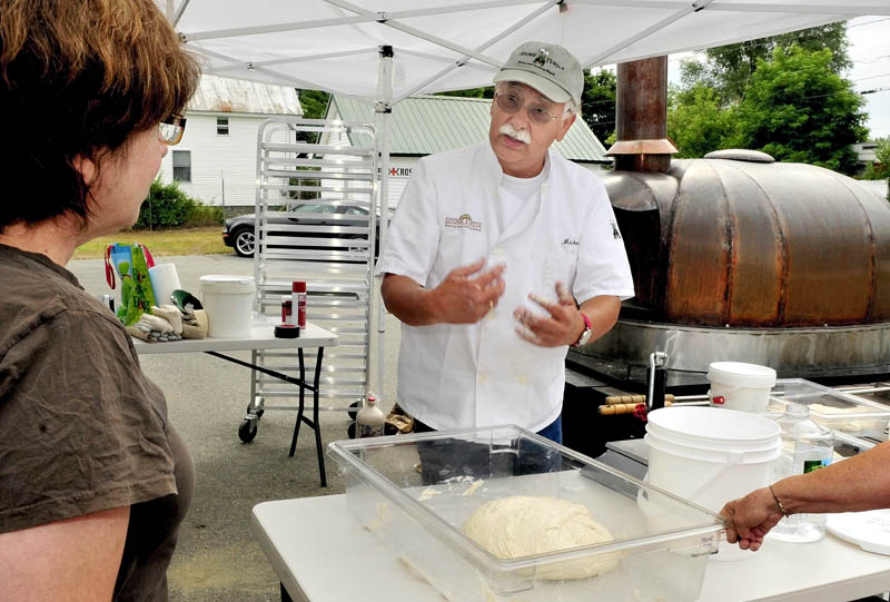 Michael Jubinsky explains the process of working with dough to Lisa Dellmo during the first day of the 2012 Kneading Conference in Skowhegan on Thursday.