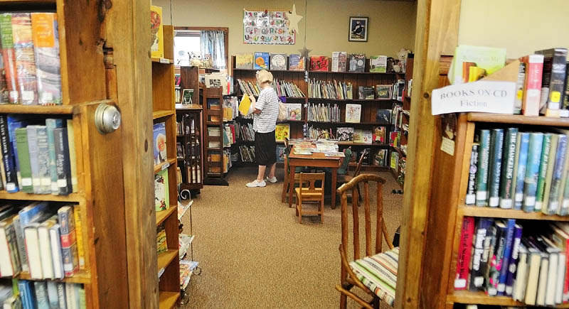 Linda Gardner looks for a book for her niece in the children's room on Saturday morning at the South China Public Library.