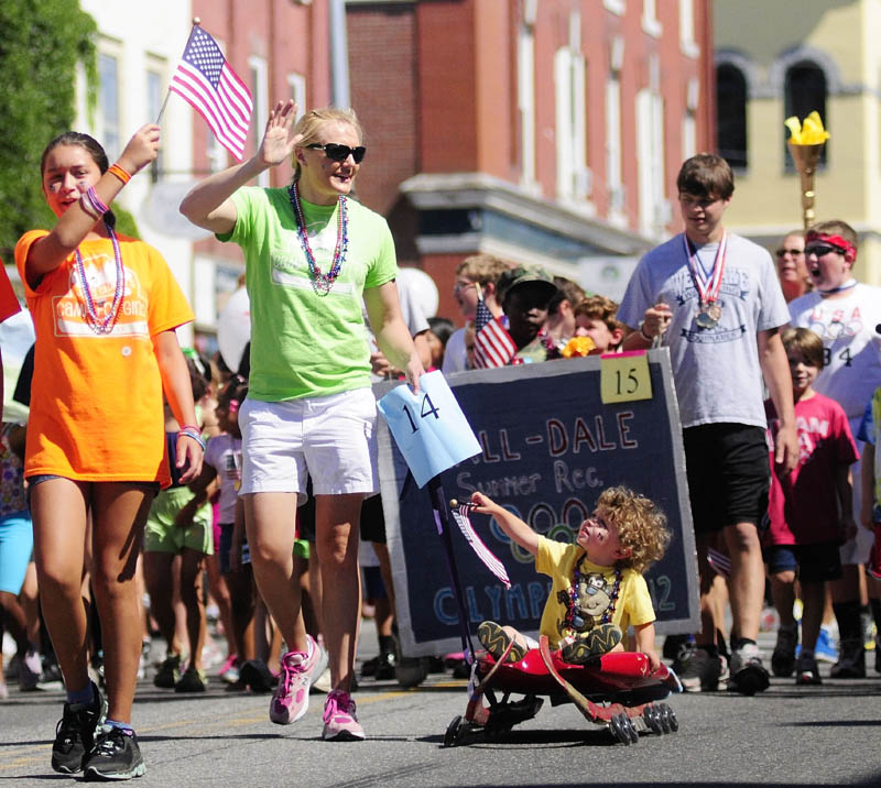 Olympic luger Julia Clukey, center, pulls Lucas Waterhouse 31⁄2, on a roller luge sled during the Old Hallowell Day parade along Water Street on Saturday morning.
