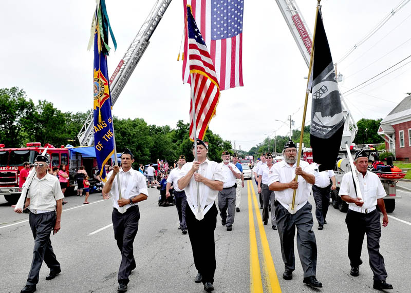 PATRIOTIC FORM: A Veterans of Foreign Wars color guard marches under an American flag during the 22nd annual Winslow Family 4th of July parade in Winslow on Wednesday. Hundreds watched the two-hour parade of floats.