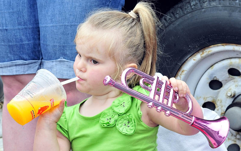 HOT PARADE: Hailee Penney takes a drink to cool off between playing a toy horn and watching the Winslow Family 4th of July parade on Wednesday.