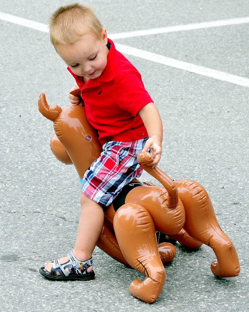 BY THE TAIL: Aiden Troxell grabs the tail of his blow-up dog while waiting for the Winslow Family 4th of July parade to start on Wednesday.