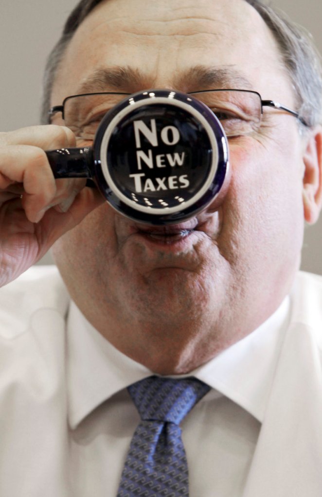 Gov. Paul LePage sips from a coffee mug displaying a message on the bottom in his office at the State House in Augusta in April.