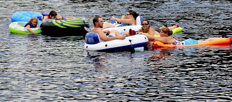 DRIFTING AWAY: These people on tubes and rafts were among the dozens who floated down the Kennebec River below the Solon/Embden bridge to cool off on Sunday.
