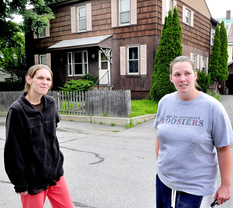 NEIGHBORS: Neighbors Jessica Veilleux, left, and Cassie Sirois speak in front of the apartment house where their neighbor Matt Savinelli was taken into custody by police Wednesday morning following a standoff.