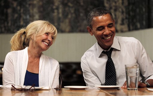 President Barack Obama, right, sits with Rose Oakleaf, left, at Mintwood Place restaurant in the Adams Morgan neighborhood in Washington, during dinner with winners of a campaign contest, Monday, Aug. 20, 2012. (AP Photo/Pablo Martinez Monsivais)