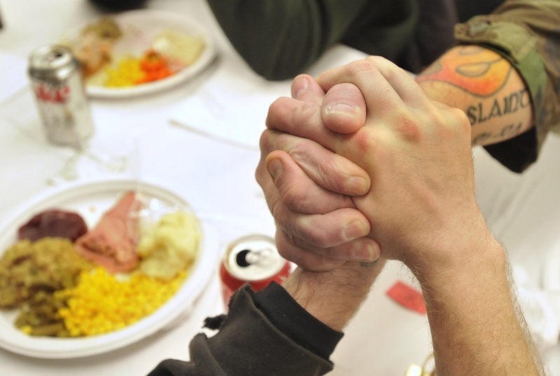 Homeless veterans join hands while attending a special dinner at Portland's Boys and Girls Club in December 2010. It's important to maintain a position at the Oxford Street Shelter to help this population.