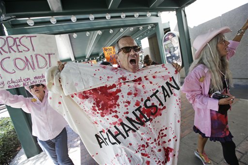 A Code Pink demonstrator chants at a venue where former Secretary of State Condoleezza Rice was to speak, Tuesday, Aug. 28, 2012, in Tampa, Fla. Protestors gathered in Tampa to march in demonstration against the Republican National Convention. (AP Photo/Dave Martin)