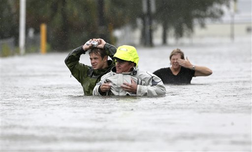 Chuck Cropp, center, his son Piers, left, and wife Liz, right, wade through floodwaters from Hurricane Isaac on Wednesday in New Orleans.