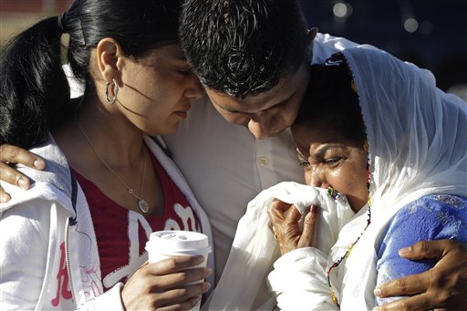 Amardeep Kaleka, son of the president of the Sikh Temple of Wisconsin, center, comforts members of the temple today in Oak Creek, Wis. Satwant Kaleka, 65, founder and president of the temple, was among four priests who died.