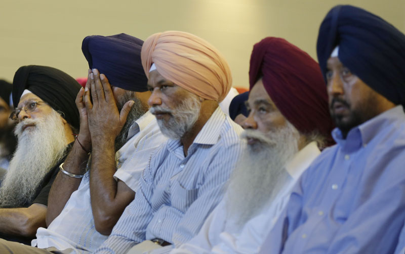 Members of the Sikh Temple of Wisconsin react at a news conference at Oak Creek Centennial church in Oak Creek, Wis. on Monday. Officials and witnesses said a gunman walked into the temple on Sunday and opened fire as several dozen people prepared for Sunday morning services. Six were killed and three were critically wounded. Shooter Wade Michael Page played in white supremacist heavy metal bands and was a "frustrated neo-Nazi," according to the Southern Poverty Law Center.
