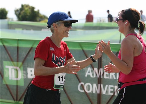 Joan Benoit Samuelson greets a runner as she crosses the finish line Saturday, Aug. 4, 2012 during the annual TD Bank Beach To Beacon 10K road race in Cape Elizabeth, Maine. (AP Photo/Joel Page)