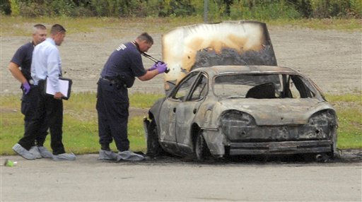 Police investigate a vehicle that burned before dawn today off Target Industrial Circle in Bangor. After the fire was extinguished, three bodies were found inside.