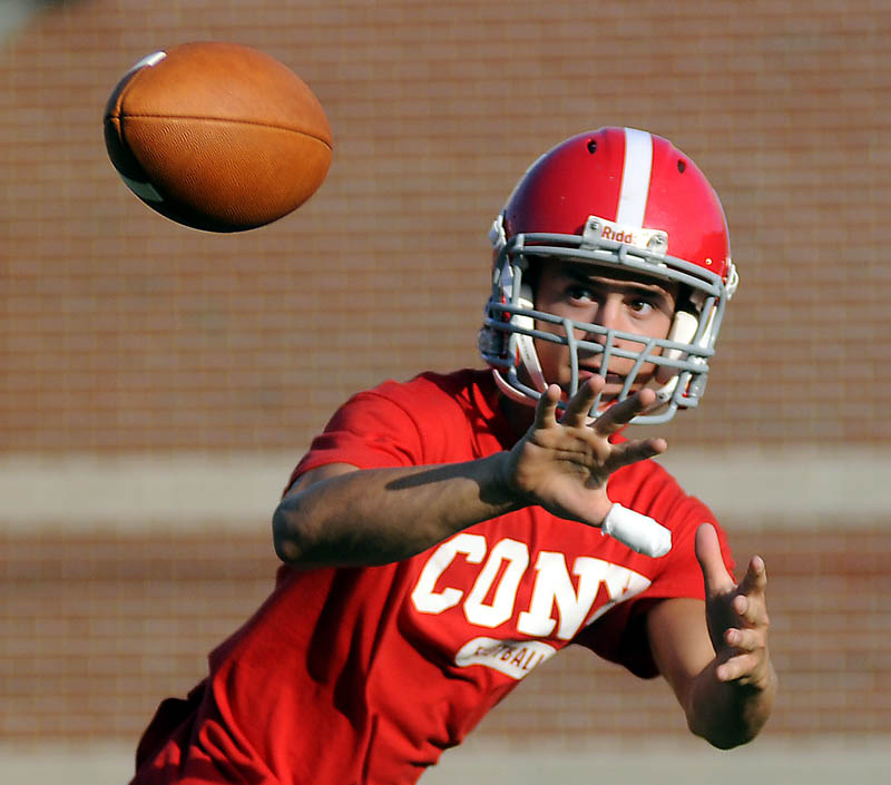 GETTING READY: Cony High School football player Chandler Shostak catches a pass Monday during the first day of practice at Cony High School in Augusta. The Rams will face Gardiner in their annual rivalry game on Friday, August 24.