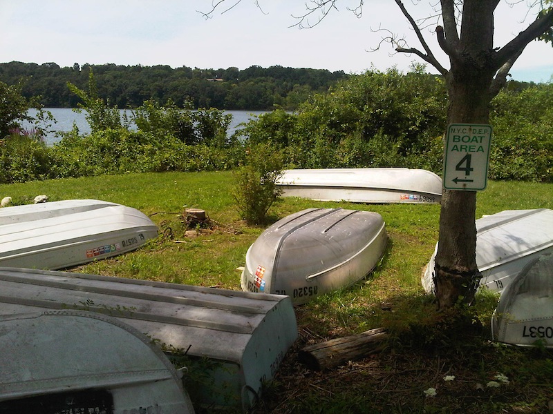 Rowboats sit on the shore of Lake Gleneida in Carmel, New York, Tuesday Aug. 7, 2012, where a woman drowned, and and a 6-year-old clinging to the floating corpse was rescued by three people fishing in a rowboat. Authorities said an autopsy was planned to determine if the woman drowned or suffered some kind of medical emergency while wading with the girl in the water. (AP Photo/Jim Fitzgerald)