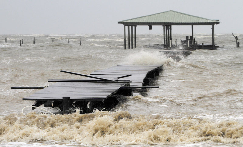 Waves tear apart a pier along the Mobile Bay near Dauphin Island on Tuesday. Alabama took a glancing blow from Hurricane Isaac on Tuesday as it headed toward landfall in the northwestern Gulf of Mexico, but the storm still threatened the coast with high winds, torrential rain and pounding surf.