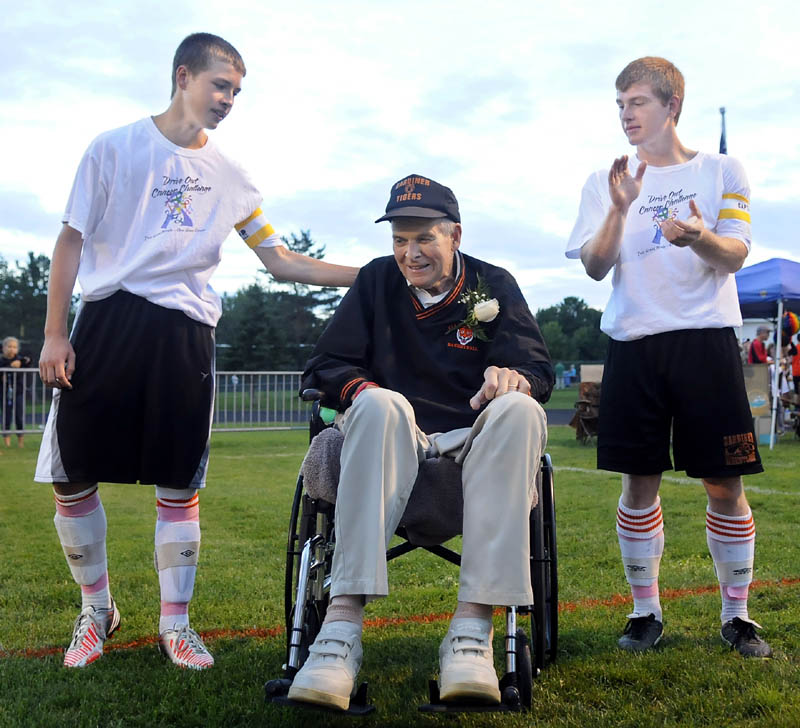 TIGER CAPTAIN: Gardiner Area High School captains Keegan Smith, left, and Daniel Del Gallo, right, introduce their honorary captain, Arthur Warren, before the boys soccer game Monday against Cony High School before the Drive Out Cancer Challenge game held in Gardiner.