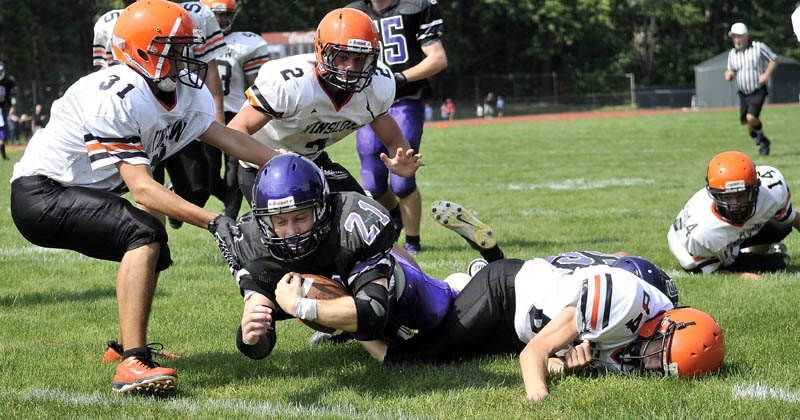 Staff photo by Michael G. Seamans Waterville Senior High School's Racean Wood, 21, dives through several Winslow High School defenders in the second quarter of an exhibition game at Waterville Senior High School Saturday.