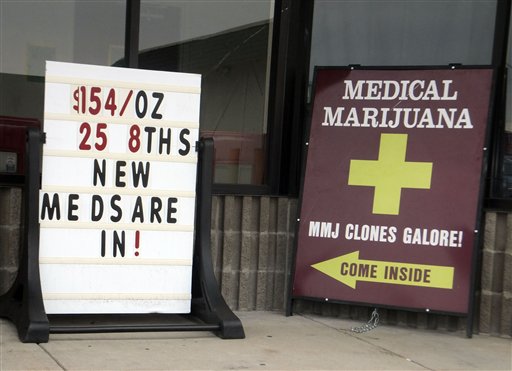 Sidewalk ads outside a west Denver medical marijuana dispensary advertise low prices and "Clones Galore!" on Monday.
