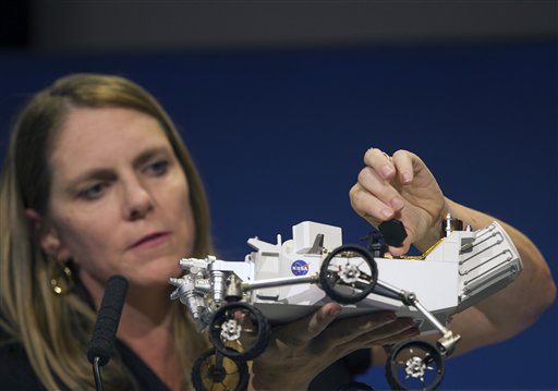 Jennifer Trosper, Mars Science Laboratory, MSL mission manager, JPL, adjusts the high-gain antenna on a rover model during a news briefing on the last data and imagery from Sol 1 at NASA's Jet Propulsion Laboratory in Pasadena, Calif., on Monday.