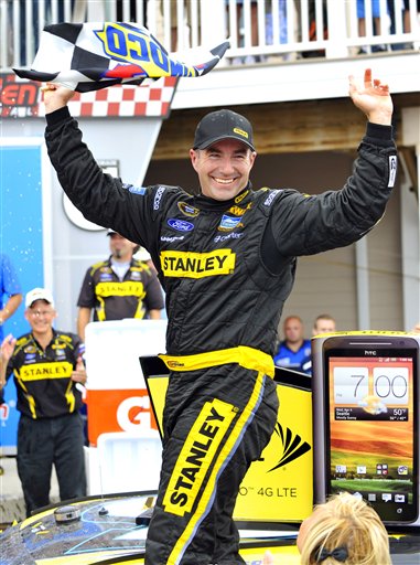 Marcos Ambrose stands on his car in victory lane as he celebrates his win at the NASCAR Sprint Cup Series at Watkins Glen International on Sunday in Watkins Glen, N.Y. 2012;Finger Lakes 355;NASCAR;Race;Watkins Glen International;August;Sprint Cup Series;Watkins Glen;New York;Autostock
