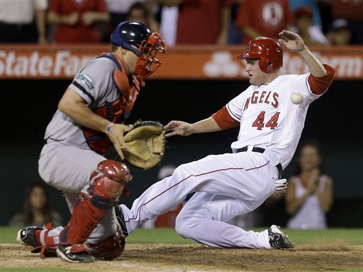 Los Angeles Angels' Mark Trumbo, left, scores on a double by Howard Kendrick past Boston Red Sox catcher Ryan Lavarnway during sixth inning of an baseball in Anaheim, Calif., Tuesday, Aug. 28, 2012. (AP Photo/Chris Carlson)