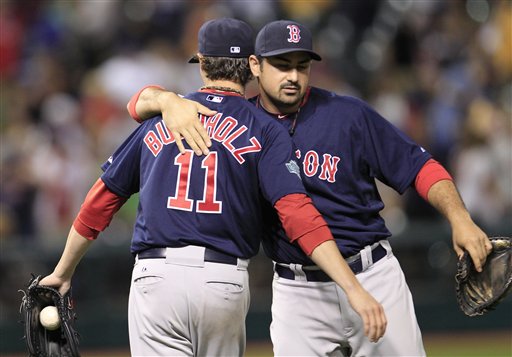Boston Red Sox's Adrian Gonzalez, right, hugs pitcher Clay Buchholz after the Red Sox defeated the Cleveland Indians 3-2 in a baseball game, Friday, Aug. 10, 2012, in Cleveland. (AP Photo/Tony Dejak)