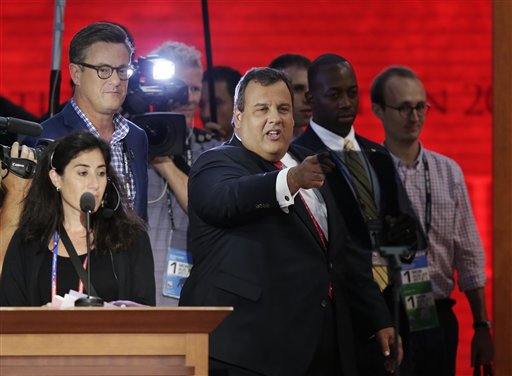 New Jersey Gov. Chris Christie, right, stands on the main stage before the start of the Republican National Convention in Tampa, Fla., on Monday.