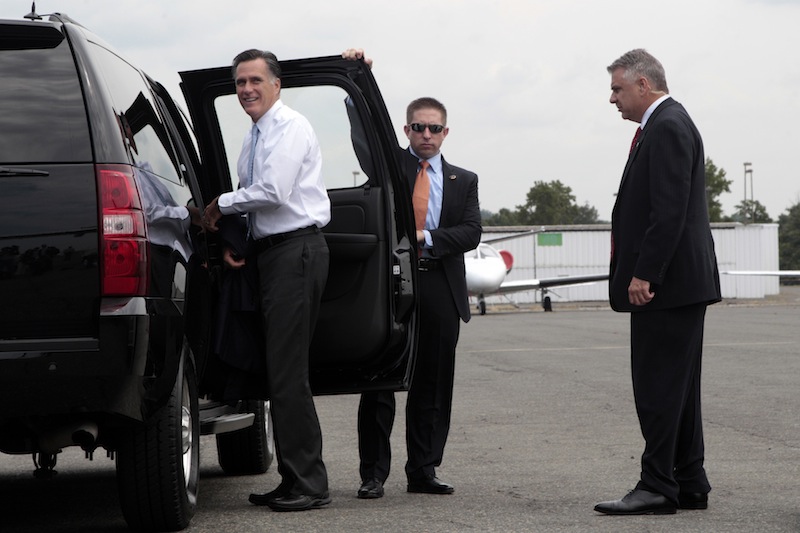 Secret Service agents stand guard as Republican presidential candidate, former Massachusetts Gov. Mitt Romney gets into his vehicle upon his arrival in Charlotte, N.C., Wednesday, Aug. 15, 2012. (AP Photo/Mary Altaffer)