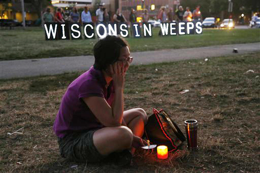 A woman sits with a candle during a vigil for the victims of the Sikh Temple shooting, in Milwaukee on Sunday.