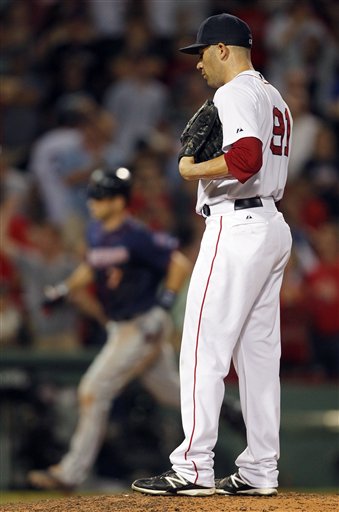 Boston Red Sox's Alfredo Aceves looks down after giving up a three-run home run to Minnesota Twins' Joe Mauer, left, in the ninth inning of a baseball game in Boston, Saturday, Aug. 4, 2012. The Twins won 6-4. (AP Photo/Michael Dwyer)