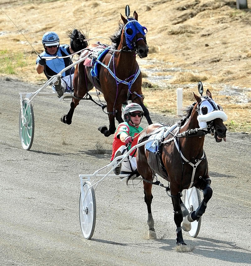 ON THE WAY TO VICTORY: Gary Mosher, foreground, drives Wholly Louy to the win during the Walter H. Hight Invitational Saturday at the Skowhegan Fairgrounds. Mr Nice Guy, driven by Kevin Switzer, background, finished second .