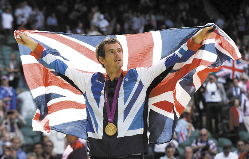 HOMETOWN HERO: Andy Murray waves the British flag during the medal ceremony for men’s singles tennis Sunday at the All England Lawn Tennis Club at Wimbledon in London. 2012 London Olympic Games Summe
