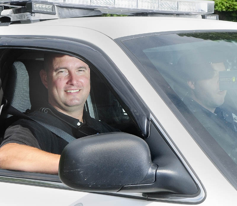 Greg Smith, the department's intensive case manager, sits in the passenger side of an Augusta police cruiser driven by Officer Nathan Walker on Wednesday afternoon.