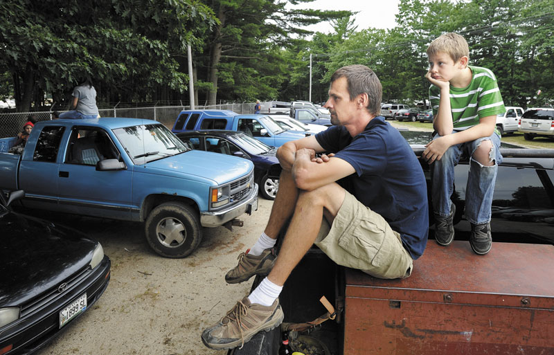 Perched atop a pickup truck to get an elevated view, Matt Hodgdon of Scarborough and his son, Josh, 10, watch stock car racing over the fence of the Beach Ridge Motor Speedway in Scarborough, Saturday, July 28.