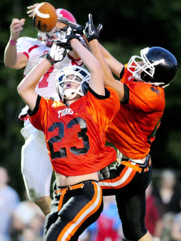Cony wide receiver Chandler Shostak, top left, can't hang onto the pass as he is double teamed by Gardiner defenders Tyler Jamison, center, (23) and Josh Moore during the Drive Out Cancer Challenge game at Hoch Field on Friday in Gardiner.