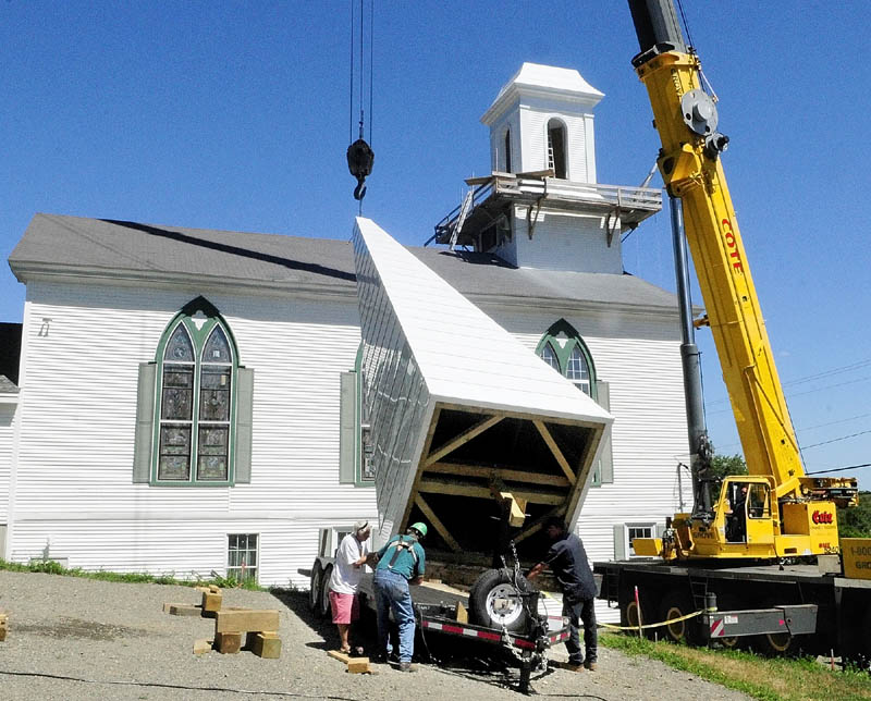 Cox Memorial Methodist Church hired steeplewright Robert Hanscom, second from left, to remove the old steeple, and build and install a new one. After being gone since last fall, a new steeple with a weather vane was put back up Tuesday morning at the corner of Middle and Central streets in Hallowell.