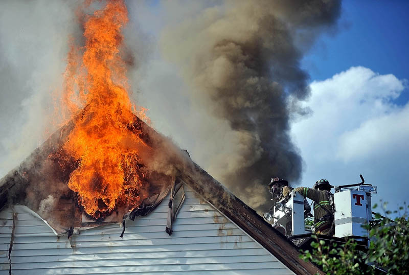 Firefighters battle a blaze on Spruce Street in Waterville Wednesday.