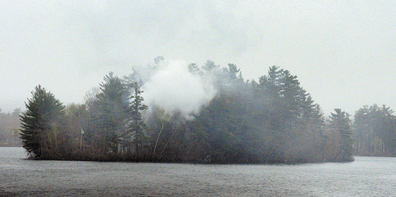 Smoke rises from a structure fire on an island in Togus Pond on Friday evening.
