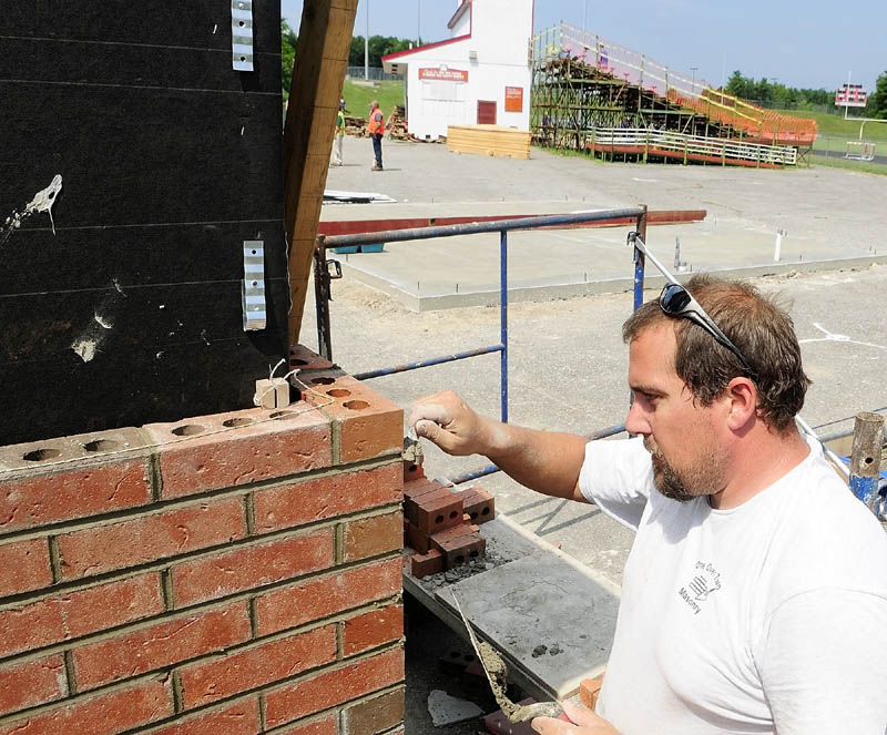 Fred Scannell, of One Over Two Masonry, mortars the joints in the brick veneer on new ticket booths at the entrance to Alumni Field at Cony High School in Augusta on Friday afternoon.
